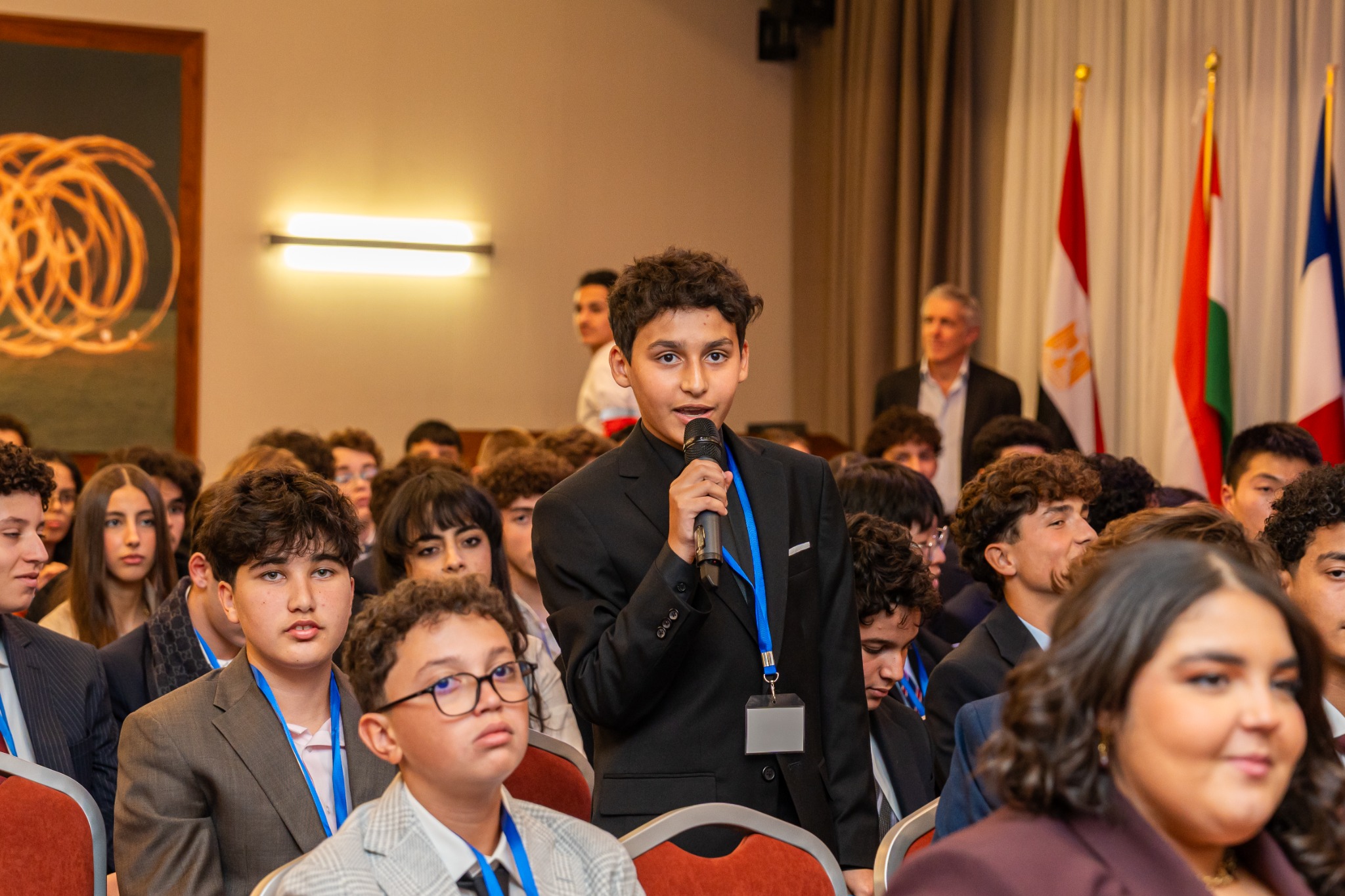 Omar speaking with a microphone at a conference